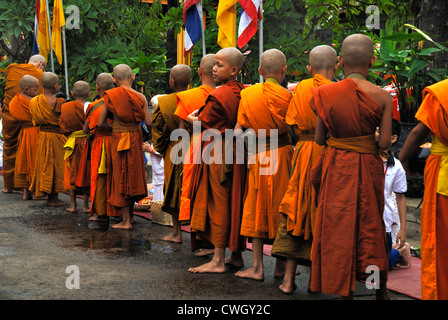 Moines recevant de la nourriture et de vos articles sur le carême bouddhiste Bouddha(jour) sur 12/08/2012 dans le nord-est de la Thaïlande Ubon Ratchathani Banque D'Images