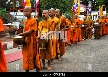 Moines recevant de la nourriture et de vos articles sur le carême bouddhiste Bouddha(jour) sur 12/08/2012 dans le nord-est de la Thaïlande Ubon Ratchathani Banque D'Images