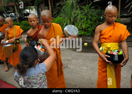 Moines recevant de la nourriture et de vos articles sur le carême bouddhiste Bouddha(jour) sur 12/08/2012 dans le nord-est de la Thaïlande Ubon Ratchathani Banque D'Images