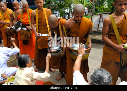 Moines recevant de la nourriture et de vos articles sur le carême bouddhiste Bouddha(jour) sur 12/08/2012 dans le nord-est de la Thaïlande Ubon Ratchathani Banque D'Images