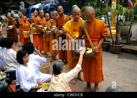 Moines recevant de la nourriture et de vos articles sur le carême bouddhiste Bouddha(jour) sur 12/08/2012 dans le nord-est de la Thaïlande Ubon Ratchathani Banque D'Images