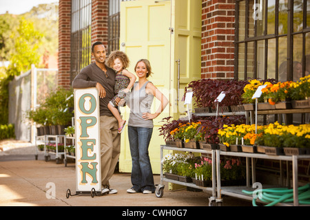 Debout près de la famille open sign fleuriste Banque D'Images