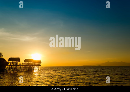 Silhouette de nipa plage huttes sur pilotis en bambou pendant le coucher du soleil Banque D'Images