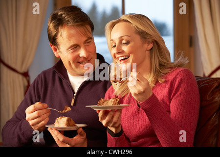 Tranche de gâteau Bridal Couple Sitting on Sofa Banque D'Images