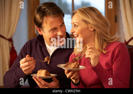 Tranche de gâteau Bridal Couple Sitting on Sofa Banque D'Images