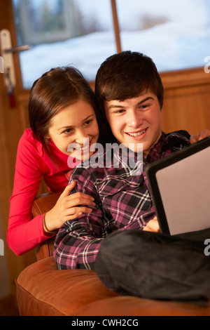 Teenage Couple Relaxing On Sofa With Tablet Computer Banque D'Images