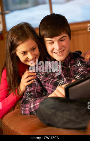 Teenage Couple Relaxing On Sofa With Laptop Banque D'Images