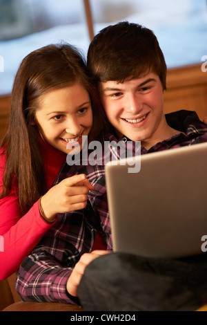 Teenage Couple Relaxing On Sofa With Laptop Banque D'Images