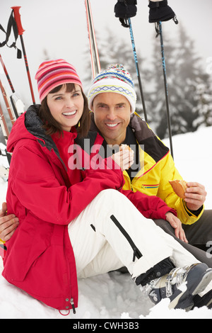 Woman Eating Sandwich sur vacances de neige en montagne Banque D'Images