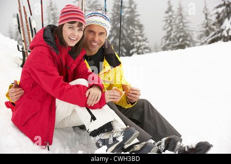 Woman Eating Sandwich sur vacances de neige en montagne Banque D'Images