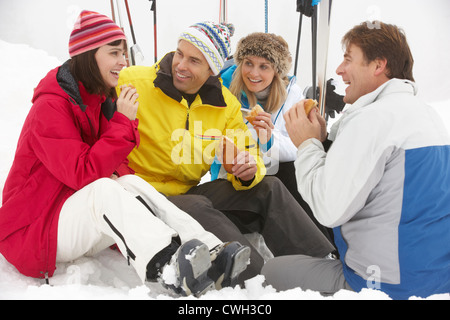 Groupe d'amis d'âge moyen Eating Sandwich sur vacances de neige en montagne Banque D'Images