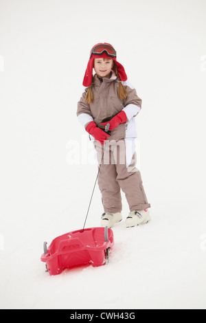 Jeune fille tirant sur traîneau vacances de neige en montagne Banque D'Images