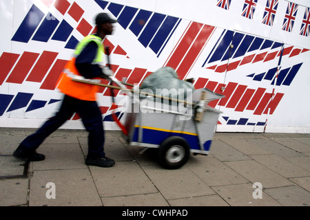 Filtre à poussière rue poussant son panier passé un grand drapeau de l'Union dans le centre de Londres Banque D'Images