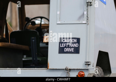 Inscrivez-vous à l'arrière d'un vieux Landrover avertissement à la suite les automobilistes qu'il est à gauche. Banque D'Images