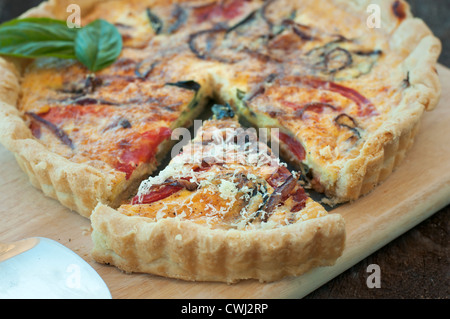 Quiche en croûte dorée avec des tomates, oignons et fines herbes Banque D'Images