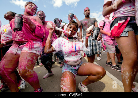 Les participants d'éclaboussures dans peinture rose au carnaval de Notting Hill 2012 Annuel Banque D'Images