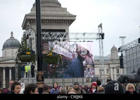 Les membres de la société Red Hat sur un bus panoramique ouvert sur l'écran d'affichage à Trafalgar Square, montrant le nouvel ans Day Parade Banque D'Images