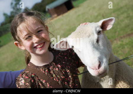 Jeune fille caressant un mouton sur une visite d'une ferme de la ville, Banque D'Images