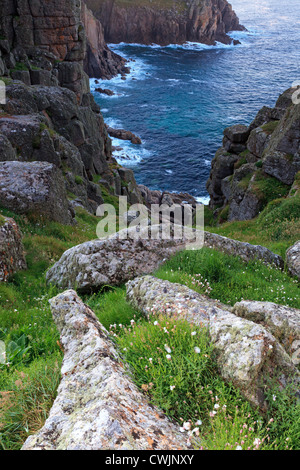 À la recherche en bas de la falaise à Pordenack Point près de Lands End en Cornouailles près d'une crique, connu sous le nom de Lions Den Banque D'Images