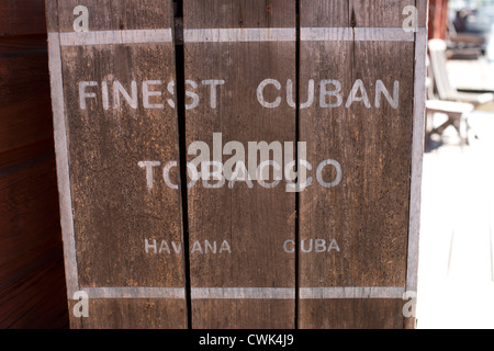 Poitrine de meilleur tabac cubain devant une maison en bois rouge Banque D'Images