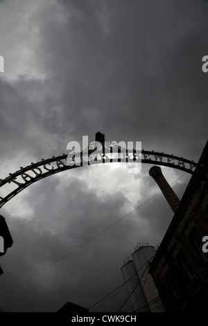 Les portes en fer forgé ornemental à Tadcaster brewery découpé sur un ciel d'orage Banque D'Images