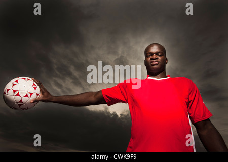 Soccer player holding ball noir Banque D'Images