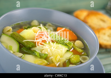 Bol plein de végétariens maison soupe minestrone italien fait d'haricots verts, courgettes, carottes, pommes de terre, poireaux et pâtes Banque D'Images