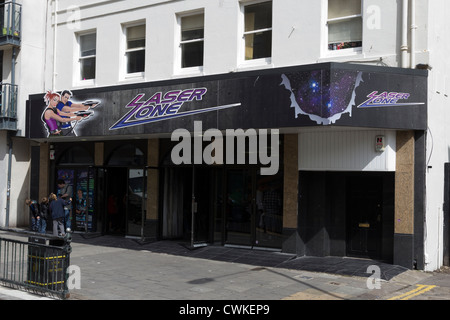 Un adulte avec trois enfants à l'extérieur Laserzone à Brighton. Banque D'Images