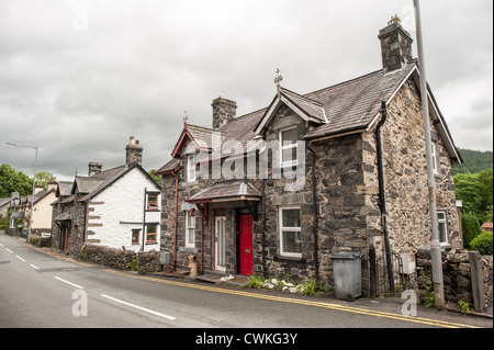 BETWS-Y-COED, pays de Galles, Royaume-Uni — Une rue pittoresque au cœur de Betws-y-Coed met en valeur le caractère charmant du village, avec des bâtiments traditionnels en pierre qui bordent l'artère. Ce pittoresque village gallois, niché dans la vallée de Conwy dans le parc national de Snowdonia, sert de porte d'entrée populaire pour les touristes explorant la beauté sauvage du nord du pays de Galles. Banque D'Images