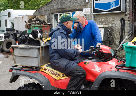 L'homme local sur quad avec son chien de berger derrière parler à station-propriétaire Banque D'Images