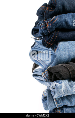 Pile de différentes teintes de bleu jeans plié sur un fond blanc Banque D'Images