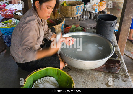 Close up portrait of horizontal d'une femme cambodgienne faire riz nouilles, kh'teaw, dans un environnement de base. Banque D'Images