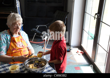 Grand-mère polonaise mûres coupe pommes jaune avec petit-fils l'âge de 86 et 6. Zawady Centre de la Pologne Banque D'Images