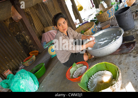 Close up portrait of vertical d'une femme cambodgienne faire riz nouilles, kh'teaw, dans un environnement de base. Banque D'Images