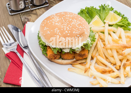 Tas de jetons avec Fish Burger sur fond de bois Banque D'Images