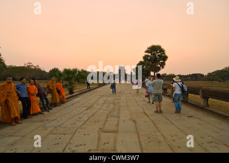 Vue horizontale de moines assis le long de la chaussée de Naga dans le soleil du soir à Angkor Wat Banque D'Images