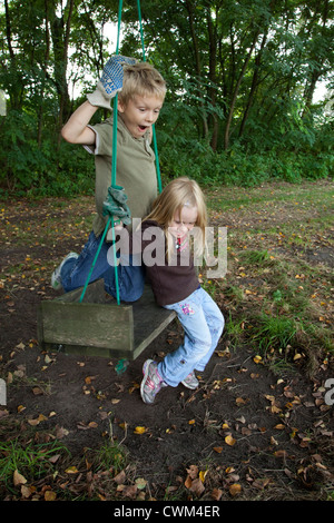 Les frères et sœurs des enfants polonais swinging sur grand swing fait maison l'âge de 8 et 4. Zawady Centre de la Pologne Banque D'Images