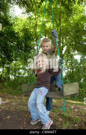 Frère et soeur polonaise à l'âge de 8 et 4 prêt à balancer sur grande maison faite de swing. Zawady Centre de la Pologne Banque D'Images