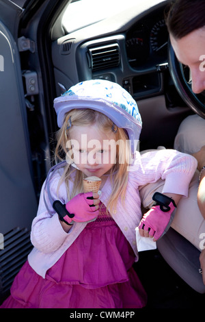 Jeune fille déterminée en tenant un cycliste une glace briser près de Mom's car l'âge de 4 et 32. La Pologne centrale Rzeczyca Banque D'Images