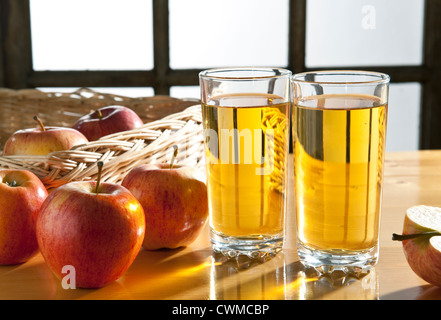 Le jus de pomme -deux verres de jus de pomme sur une table de cuisine, avec des pommes Banque D'Images