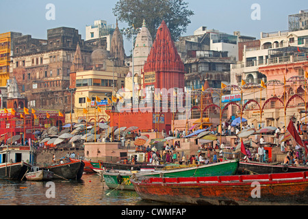 Pèlerins visitant la ville sainte et des barques colorées sur le Gange à Varanasi, Uttar Pradesh, Inde Banque D'Images