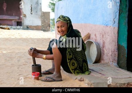 La cuisine femme dans la rue, Gharb Soheil Nubian Village sur la rive ouest du Nil à Assouan Egypte suivant Banque D'Images