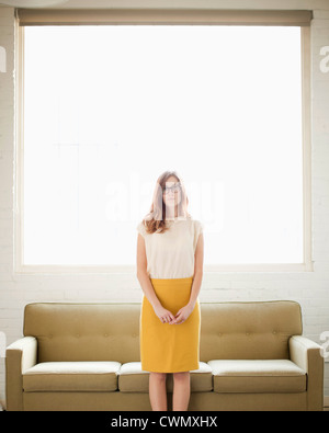 USA, Utah, Salt Lake, Portrait of young woman standing in front of canapé Banque D'Images