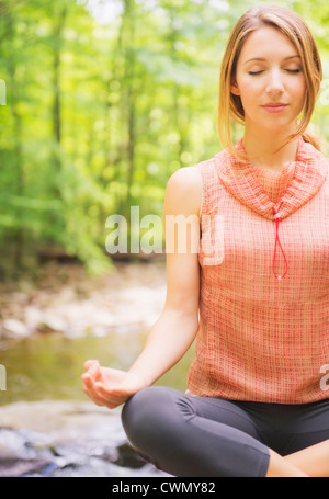 USA, New Jersey, Mendham, Woman in forest joga Banque D'Images