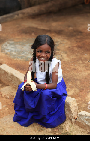 Les jeunes filles rurales indiennes manger une banane de l'Andhra Pradesh en Inde du Sud Banque D'Images