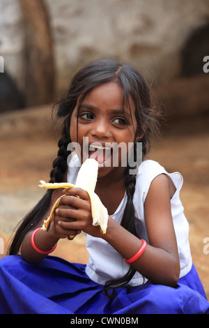 Les jeunes filles rurales indiennes manger une banane de l'Andhra Pradesh en Inde du Sud Banque D'Images