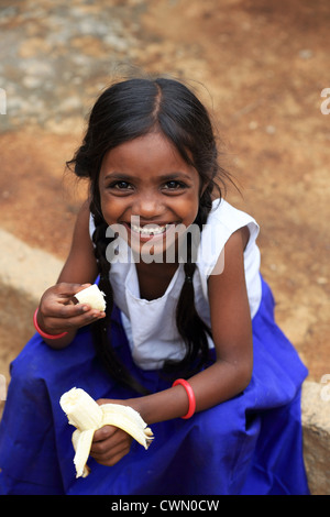 Les jeunes filles rurales indiennes manger une banane de l'Andhra Pradesh en Inde du Sud Banque D'Images