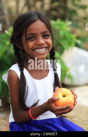 Les jeunes filles rurales indiennes de manger une pomme l'Andhra Pradesh en Inde du Sud Banque D'Images