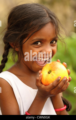 Les jeunes filles rurales indiennes de manger une pomme l'Andhra Pradesh en Inde du Sud Banque D'Images