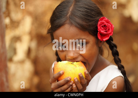 Les jeunes filles rurales indiennes de manger une pomme l'Andhra Pradesh en Inde du Sud Banque D'Images